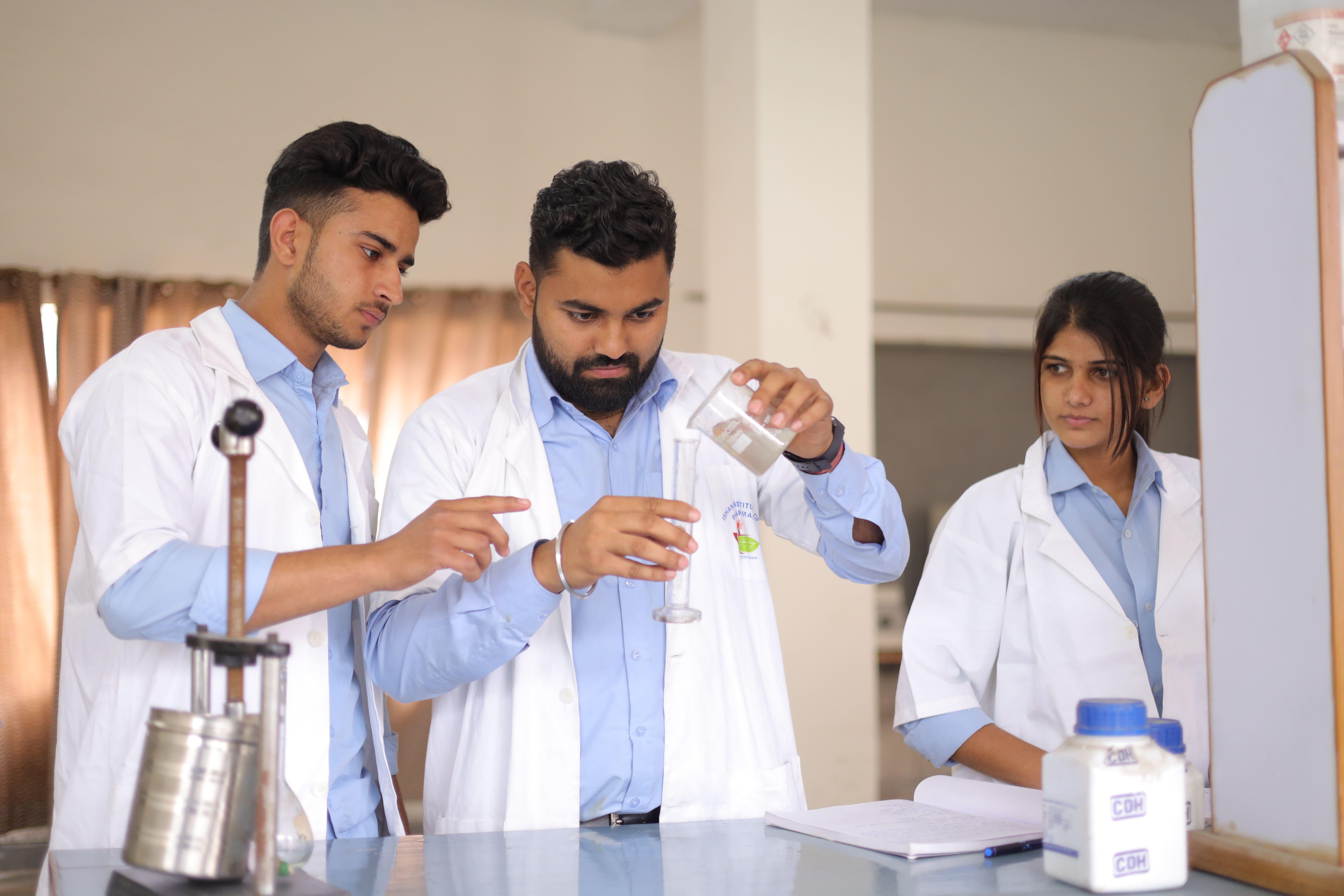 Best Pharmacy college student performing pharmaceutical laboratory experiment at Ishan Greater Noida.